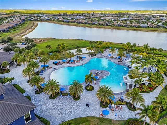 Aerial perspective of suburban area with a large body of water and a pool area