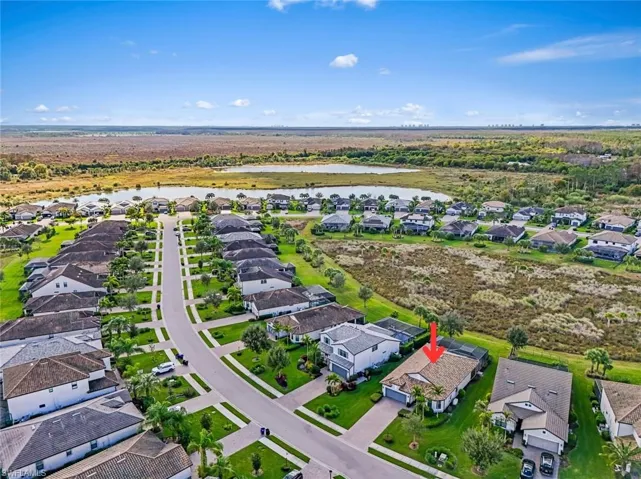 Aerial view of property and surrounding area featuring nearby suburban area and a large body of water