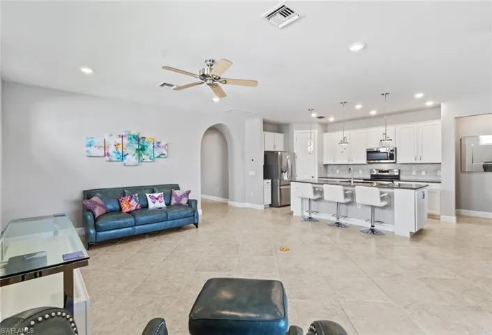 Living room featuring arched walkways, a ceiling fan, recessed lighting, and light tile patterned flooring