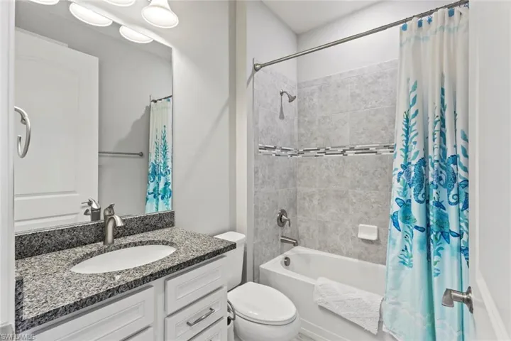 Bathroom featuring shower / tub combo with curtain and vanity
