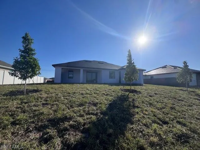 Back of property with a lawn