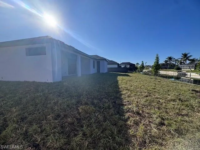 View of side of home with a yard