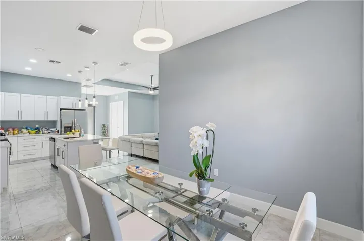 Dining space with light marble finish flooring and recessed lighting