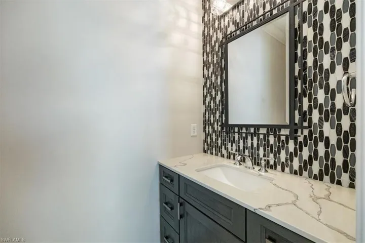 Bathroom with vanity and tasteful backsplash