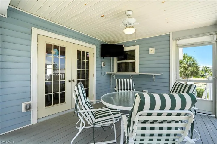 Wooden terrace with french doors and outdoor dining space - Virtually Edited Image