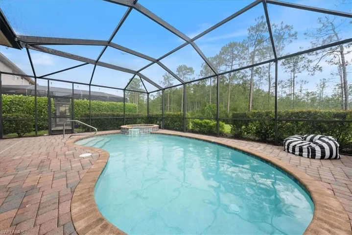 View of pool with a pool with connected hot tub, a lanai, and a patio area