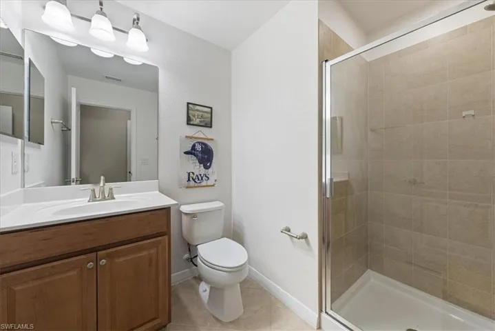 Full bathroom featuring a shower stall, vanity, and tile patterned flooring