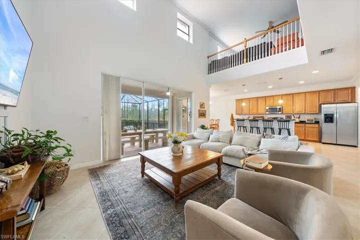Living area with light tile patterned floors and a towering ceiling