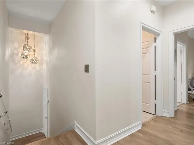 Staircase with striking lighting, wood floors and custom lucite railings