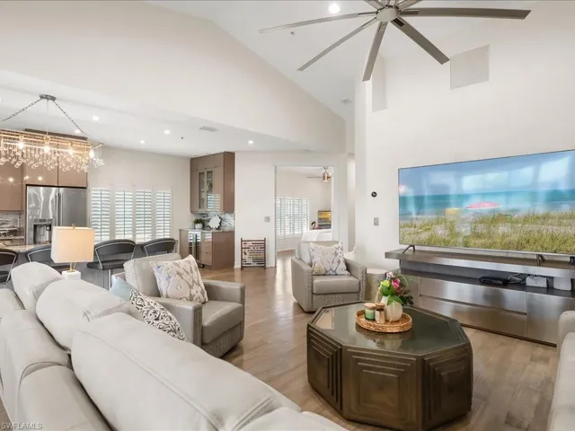 Spacious Living room featuring wood floors, modern ceiling fan, and lovely vaulted ceiling