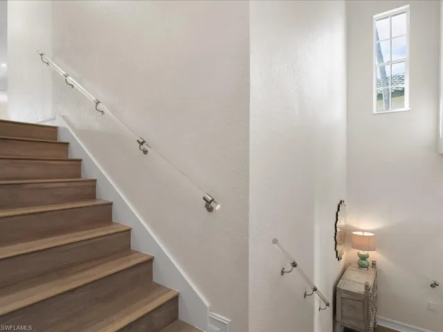 Staircase with striking lighting, wood floors and custom lucite railings