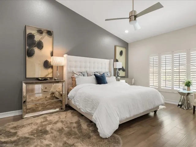 Spacious Master Bedroom featuring wood floors, vaulted ceiling, ensuite bathroom