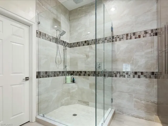 Full ensuite bathroom with double vanity, quartzite countertop and European cabinets and tile walls