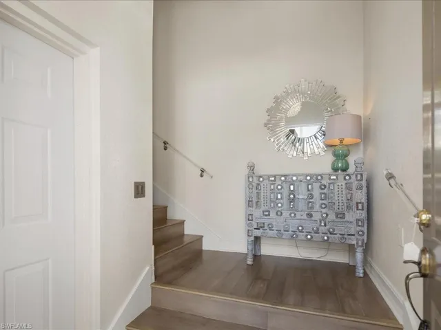Staircase with striking lighting, wood floors and custom lucite railings