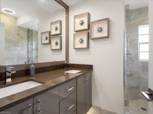 Full bathroom with double sink, quartzite countertops, full tile, LED lighting and European Cabinets