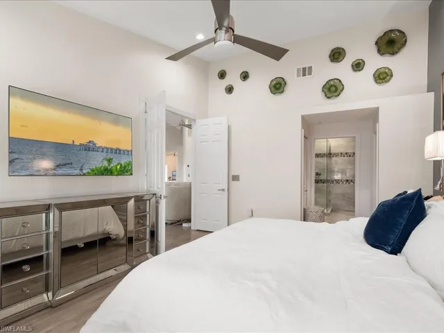 Spacious Master Bedroom featuring wood floors, vaulted ceiling, ensuite bathroom