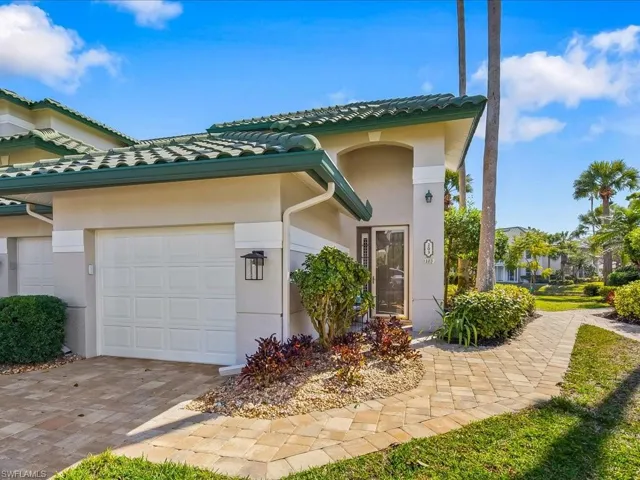 View of front of house featuring an attached garage, stucco siding, and driveway