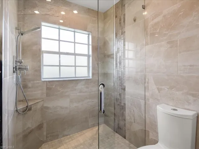 Full bathroom with double sink, quartzite countertops, full tile, LED lighting and European Cabinets