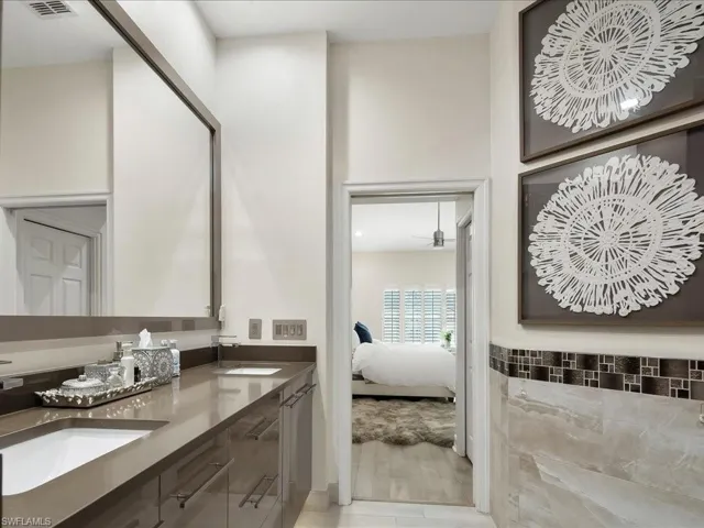 Full ensuite bathroom with double vanity, quartzite countertop and European cabinets and tile walls