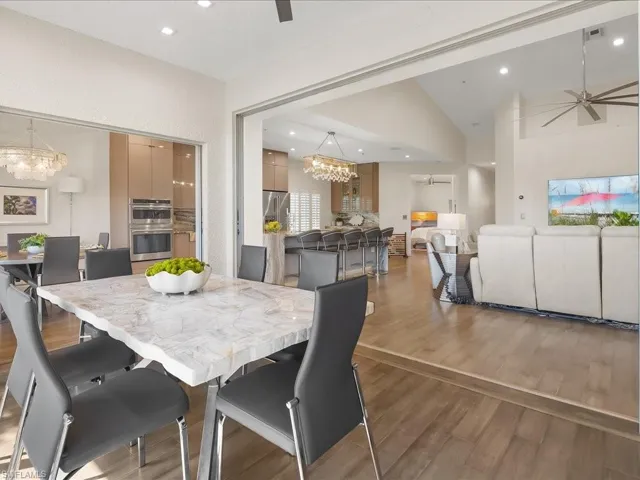 Dining area with lovely golf course and lake views, a modern ceiling fan, light wood floors, and recessed lighting
