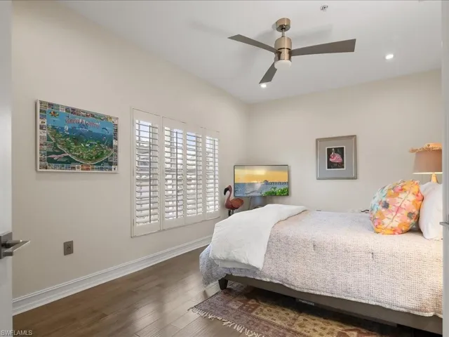 Guest Bedroom #2 featuring wood, high ceilings, plantation shutters and modern ceiling fan