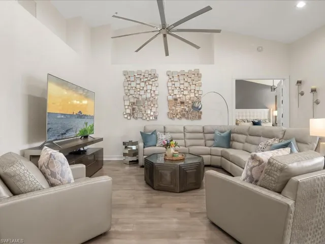 Spacious Living room featuring wood floors, modern ceiling fan, and lovely vaulted ceiling