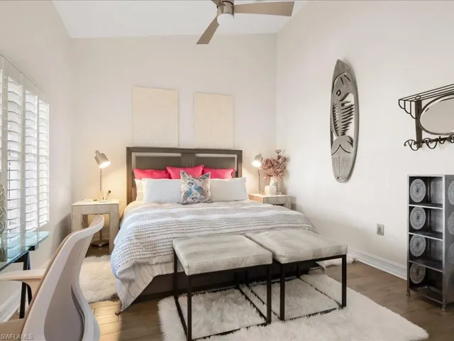 Guest Bedroom #1 featuring wood, high ceilings, plantation shutters and modern ceiling fan