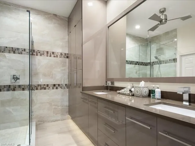 Full ensuite bathroom with double vanity, quartzite countertop and European cabinets and tile walls