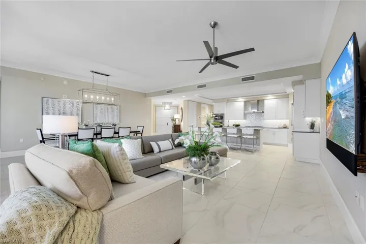 Notice the designer lighting, oversized seating, and the perfect flow into the dining and kitchen areas.