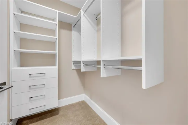 Primary bedroom suite with TWO closets - both with custom built-in shelving, drawers, and abundant hanging space for beautifully organized storage.
