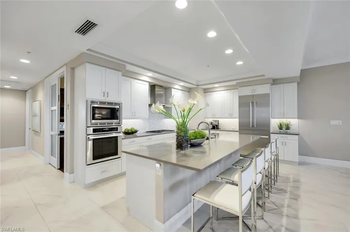 Another angle of the stunning chef’s kitchen showcasing the expansive island, sleek appliances, and plenty of space for everyone to gather!