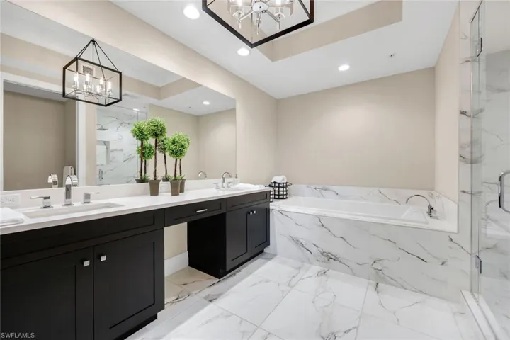 Luxurious primary bath featuring marble-style finishes, an oversized soaking tub, and sleek modern fixtures for a true spa experience!