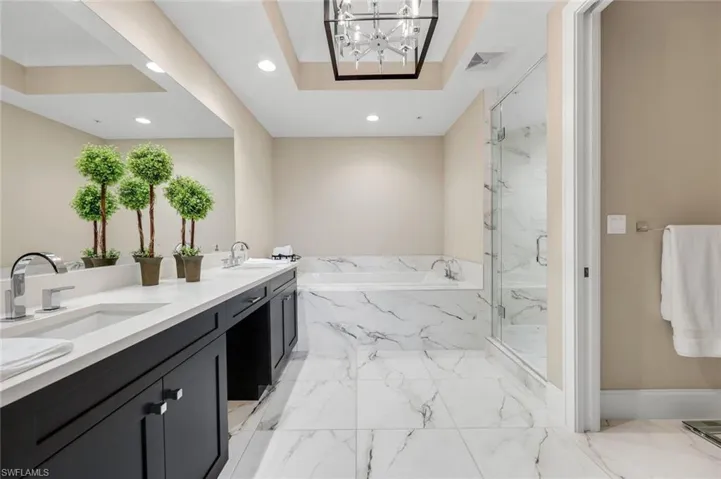 Spa-inspired primary bath with dual vanities, soaking tub, and a stunning glass-enclosed walk-in shower for total relaxation!