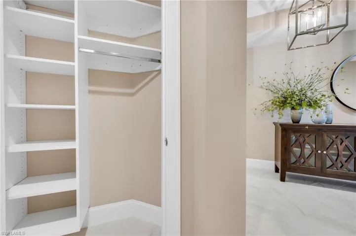 Closet with built-in shelving and hanging space for convenient everyday storage, located off the entry foyer.