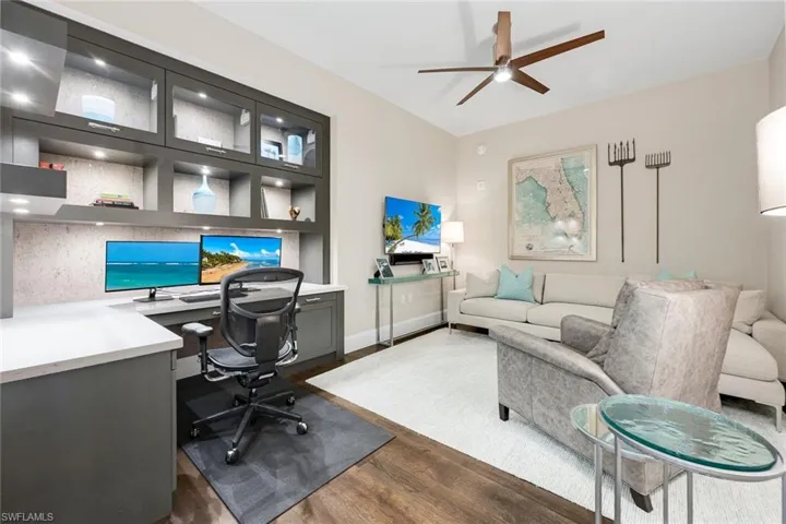 Stylish den and home office with custom built-ins, warm wood flooring, and plenty of space to work, relax, or host overnight guests.