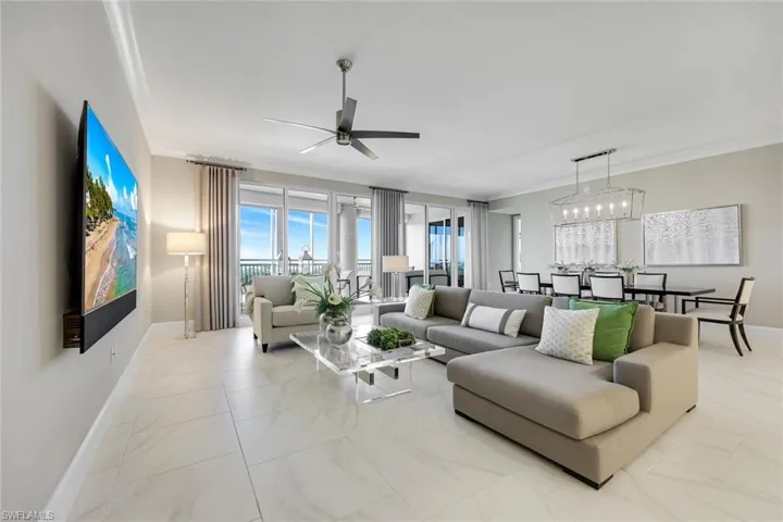 Wide-open great room with soaring ceilings, sleek tile flooring, and walls of glass filling the space with beautiful natural light!