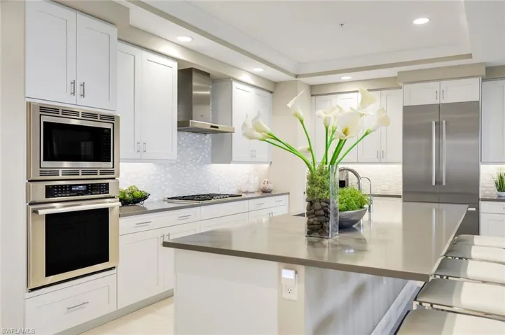 Sleek gas cooktop, double wall ovens, and crisp white cabinetry — a dream setup for any home chef!