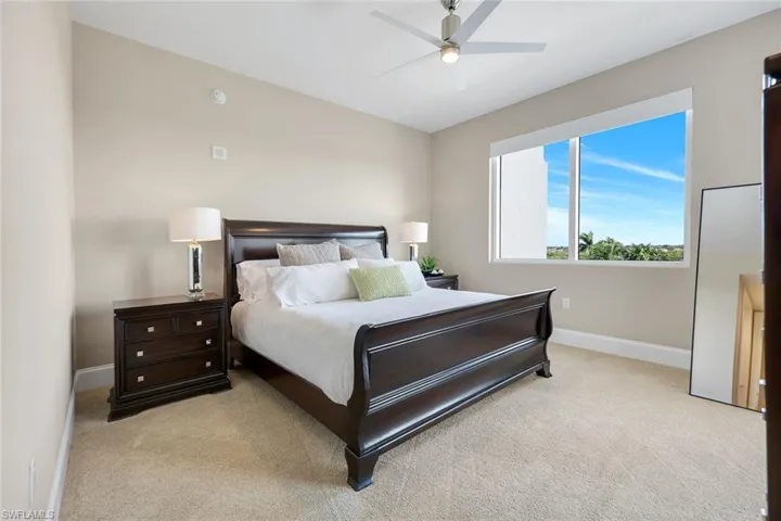 Spacious ensuite guest bedroom with soft natural light, plush carpeting, and a peaceful, inviting atmosphere for guests to unwind!