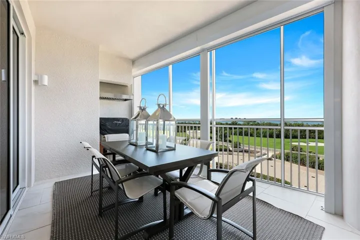 Outdoor dining on the screened terrace with built-in grill and beautiful open views — perfect for alfresco meals year-round.