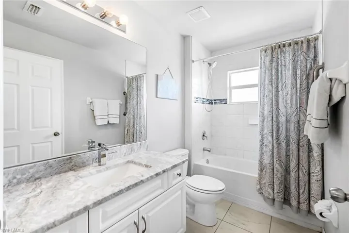 Full bathroom with vanity, toilet, and shower / bath combo