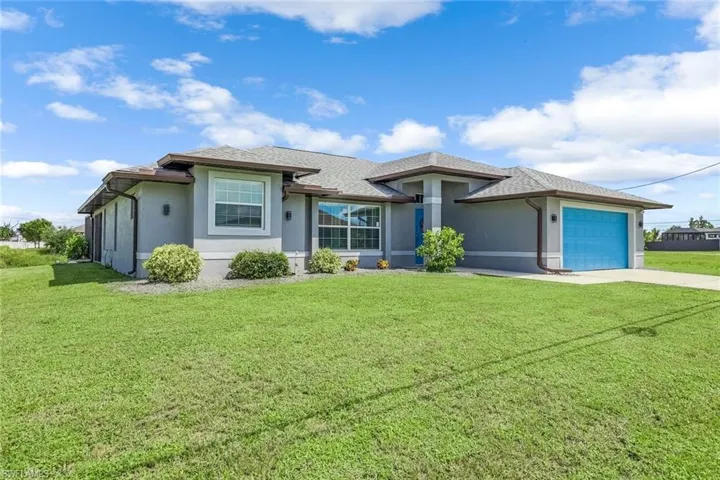View of front of property featuring a garage and a front lawn