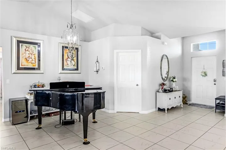 Misc room with a notable chandelier and high vaulted ceiling