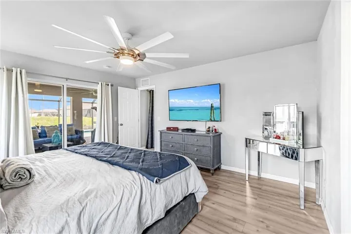 Bedroom featuring ceiling fan, access to exterior, and light hardwood / wood-style flooring