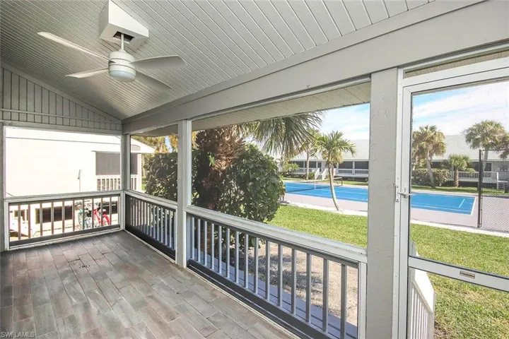 Unfurnished sunroom overlooking the yard and tennis courts