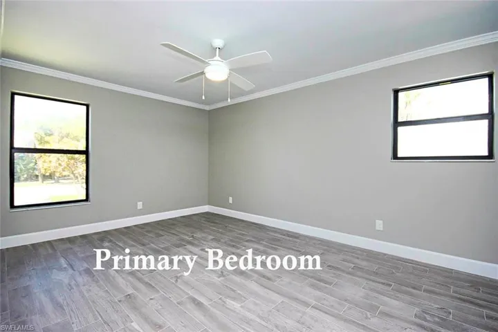 Primary Bedroom featuring crown molding, ceiling fan, and vinyl wood plank flooring