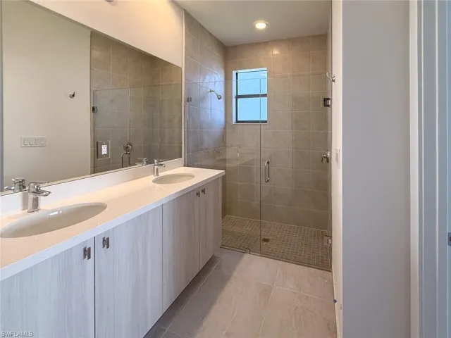 Bathroom with vanity, tile patterned floors, and an enclosed shower