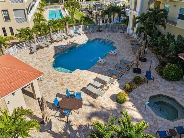 Community pool with a patio and a hot tub