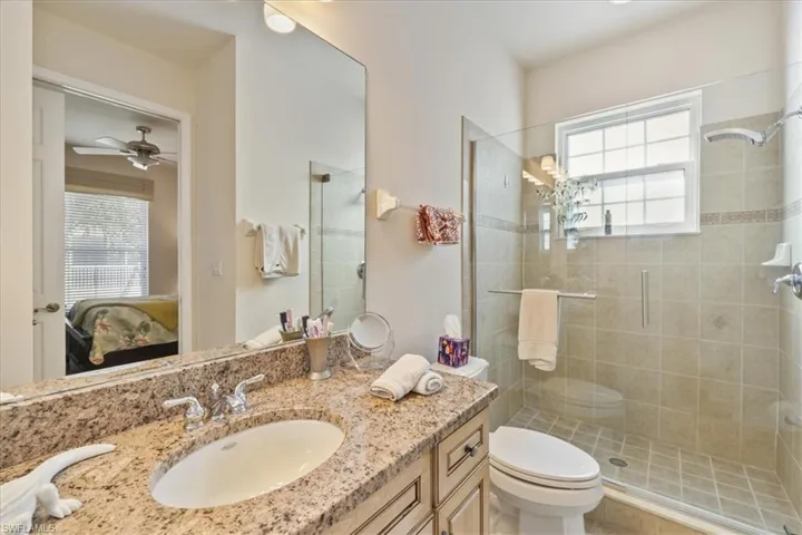 Ensuite bathroom featuring vanity, healthy amount of natural light, and a shower stall