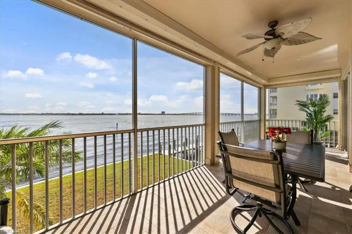 Sunroom / solarium with a water view and tile patterned flooring