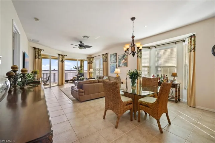 Dining room with light tile patterned flooring, a chandelier, and a ceiling fan